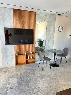 a lobby with a table and chairs and a tv at Studio Usio in Casablanca