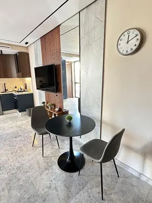 a living room with a table and chairs and a clock at Studio Usio in Casablanca