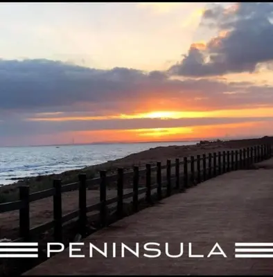a fence on the beach with the sunset in the background at Peninsula Dar Bouazza in Tamaris