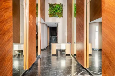 a hallway with wooden walls and tables in a building at Appartement de luxe - Les Princesses avec Parking in Casablanca