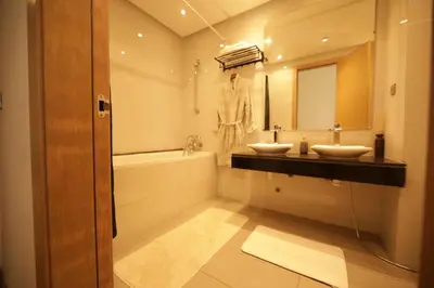 a bathroom with two sinks and a mirror at 165m luxury Family apartment in prestigia rabat in Rabat