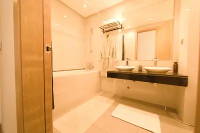 a bathroom with two sinks and a tub and a mirror at 165m luxury Family apartment in prestigia rabat in Rabat