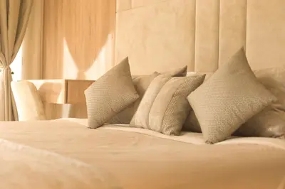 a white bed with pillows on top of it at 165m luxury Family apartment in prestigia rabat in Rabat