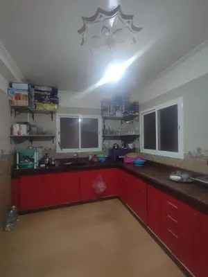 a kitchen with red cabinets and two large windows at Big family house sohofi in Casablanca