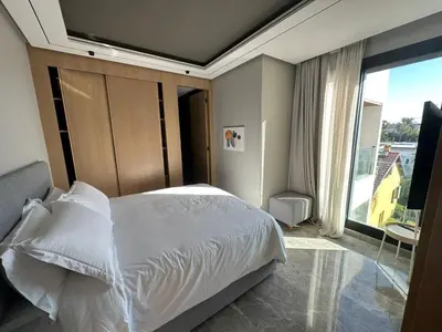 a bedroom with a white bed and a large window at TheBesty Ocean Suite -By Appart'Ayla in Anfa-Supérieur