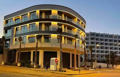 a large building with palm trees in front of it at TheBesty Ocean Suite -By Appart'Ayla in Anfa-Supérieur