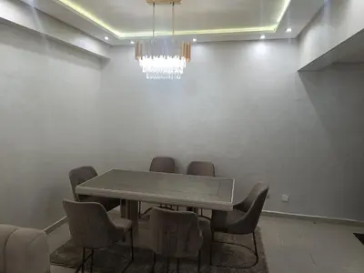 a dining room with a table and chairs and a chandelier at Appartement a belvédère in Casablanca