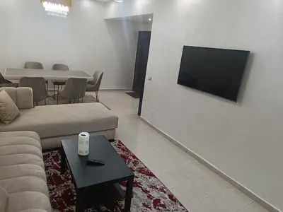 a living room with a couch and a tv on a wall at Appartement a belvédère in Casablanca