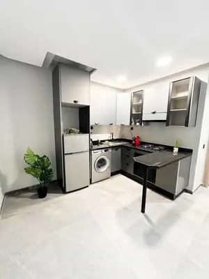 a kitchen with stainless steel appliances and a table at familyconfort casa evasion in Casablanca