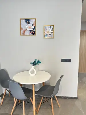 a table with two chairs and a vase on it at familyconfort casa evasion in Casablanca