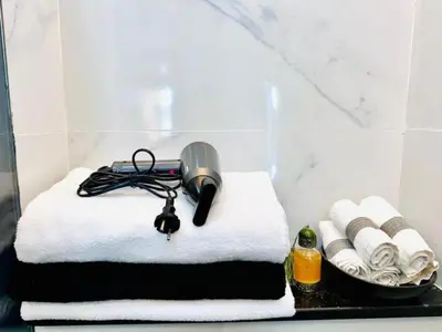 a room with towels and a blow dryer on a counter at Elegant 3BR Stay 5min to Hay Riad in Temara
