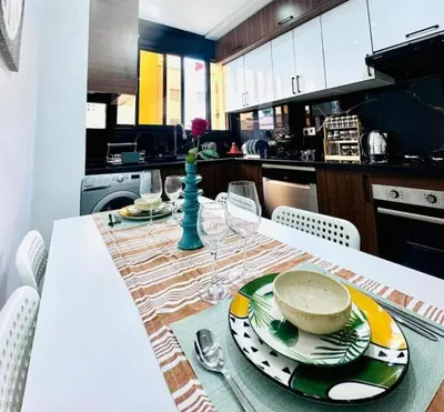 a kitchen with a table with plates and dishes on it at Elegant 3BR Stay 5min to Hay Riad in Temara