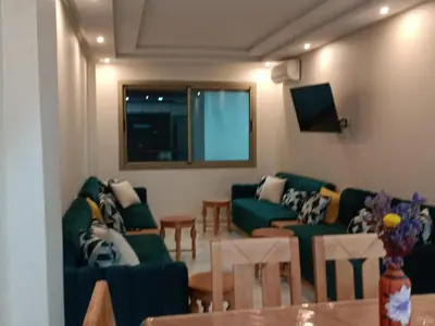 a living room with green couches and a television at Bati d or in Mohammedia