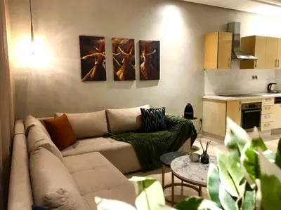 a living room with a couch and a kitchen at Cosy C35 in Casablanca