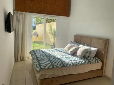 a bedroom with a bed with pillows and a window at Melrose beach apartment in Tamaris