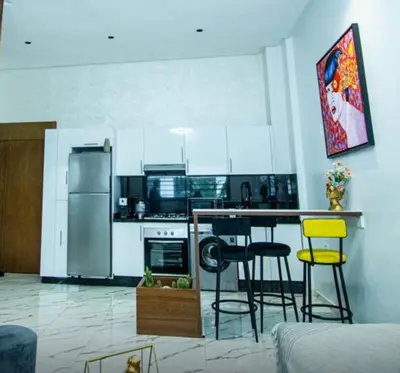 a kitchen with white cabinets and yellow bar stools at casablanca maroc in Casablanca