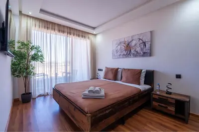 a bedroom with a large bed with two shoes on it at Appartement Sublime avec Piscine in Mansouria