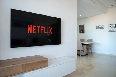 a tv on a wall with the netflix sign on it at Appartement Sublime avec Piscine in Mansouria