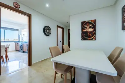 a dining room with a white table and chairs at Appartement Sublime avec Piscine in Mansouria