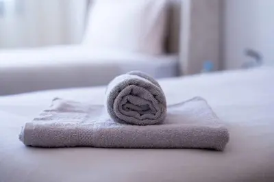 a rolled up towel sitting on top of a bed at Appartement Sublime avec Piscine in Mansouria