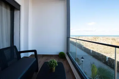 a balcony with a couch and a view of the ocean at Appartement Sublime avec Piscine in Mansouria