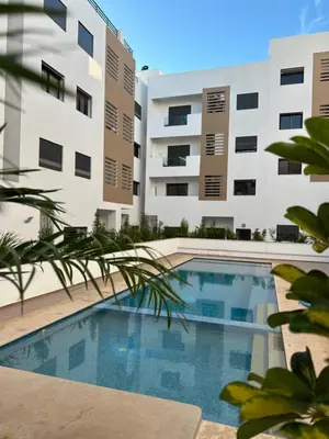 a swimming pool in front of a building at Bel Appartement à Harhoura pour les familles in El Harhoura