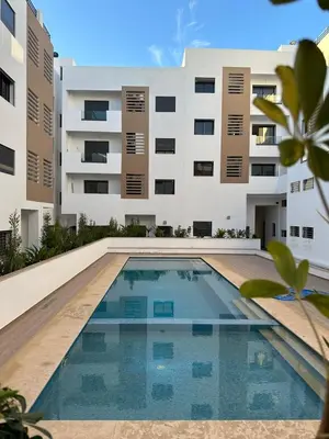 a swimming pool in front of a building at Bel Appartement à Harhoura pour les familles in El Harhoura