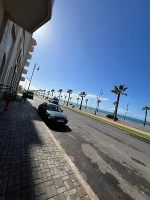 a car parked on the side of a road next to the beach at L'Appart du Carousel in Rabat