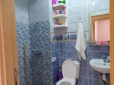 a blue tiled bathroom with a toilet and a sink at confy house in Casablanca