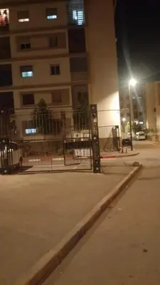 a fence in front of a building at night at confy house in Casablanca