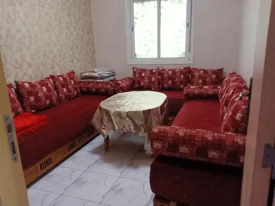 a living room with a red couch and a table at confy house in Casablanca