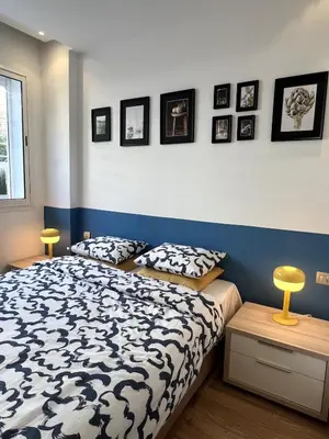 a bedroom with a black and white bed and pictures on the wall at 1 bed apt In Prestigia hay Riad rabat in Rabat