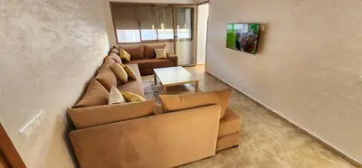 a living room with a couch and a table at Appartement ALAA - Malaga beach in Mansouria