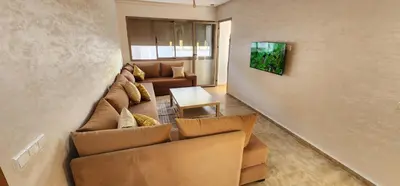 a living room with a couch and a table at Appartement ALAA - Malaga beach in Mansouria