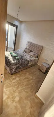 a bedroom with a bed in the corner of a room at Appartement ALAA - Malaga beach in Mansouria