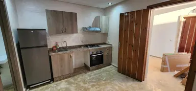 a kitchen with a refrigerator and a stove top oven at Appartement ALAA - Malaga beach in Mansouria
