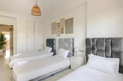 two beds in a room with white walls at Rabat Centro Apartments in Rabat
