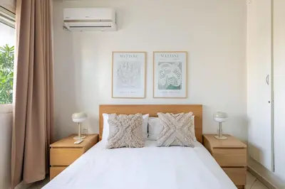 a bedroom with a white bed with two night stands at Rabat Centro Apartments in Rabat