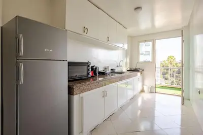 a kitchen with a stainless steel refrigerator and white cabinets at Rabat Centro Apartments in Rabat