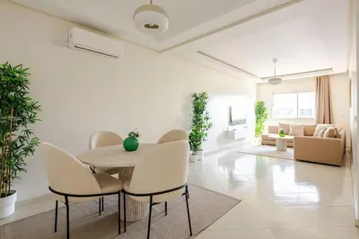 a white living room with a table and chairs at Rabat Centro Apartments in Rabat
