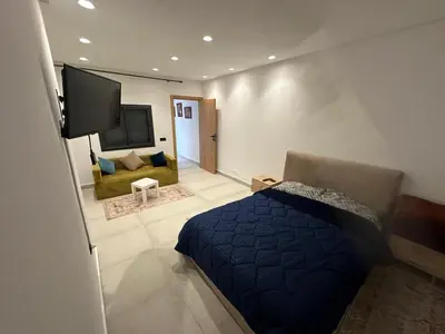a bedroom with a bed and a tv and a couch at زنقة توبقال أكدال عمارة 24 رقم 3 in Rabat