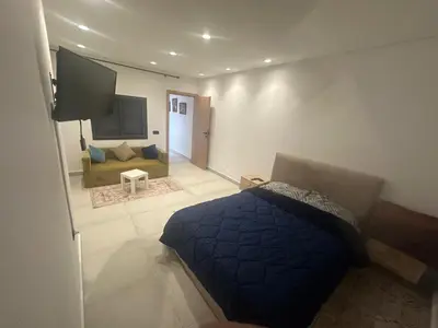 a bedroom with a blue bed and a couch at زنقة توبقال أكدال عمارة 24 رقم 3 in Rabat
