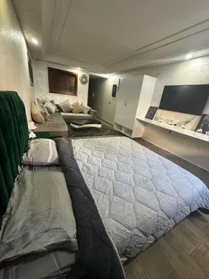 a large bedroom with a large bed and a couch at شقة فأكدال in Rabat