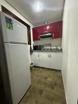 a kitchen with white cabinets and a refrigerator at شقة فأكدال in Rabat