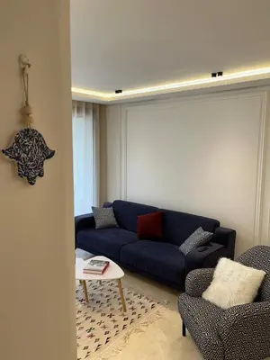 a living room with a blue couch and two chairs at Cocon au coeur de Casablanca in Casablanca