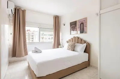 a white bedroom with a large bed and a window at Spacious 2Bedrooms Fully equipped-5min Agdal Station in Rabat
