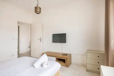 a bedroom with a bed and a tv on the wall at Spacious 2Bedrooms Fully equipped-5min Agdal Station in Rabat