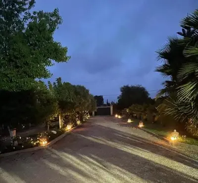an empty road with lights on the sides of it at Magnifique Chalet en bois collé à la forêt de Benslimane in O Ben Slimane