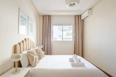 a bedroom with a white bed with a window at Modern 1 Bedroom W Terrace- Rabat City Center in Rabat