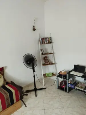 a room with a bed and a fan and a shelf at résidence les perles de Bouznika in Bouznika